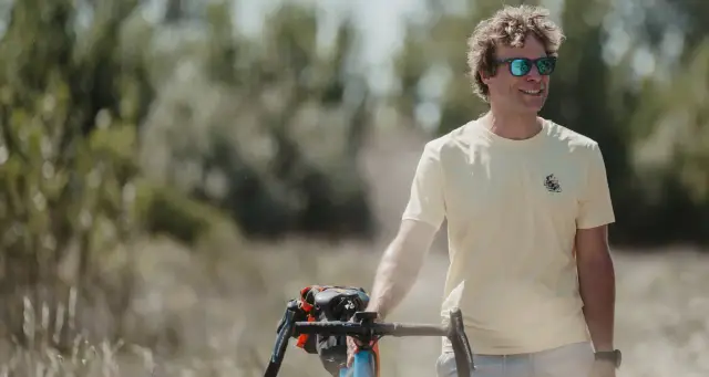 Wielrenner met gravelfiets in een zomers landschap