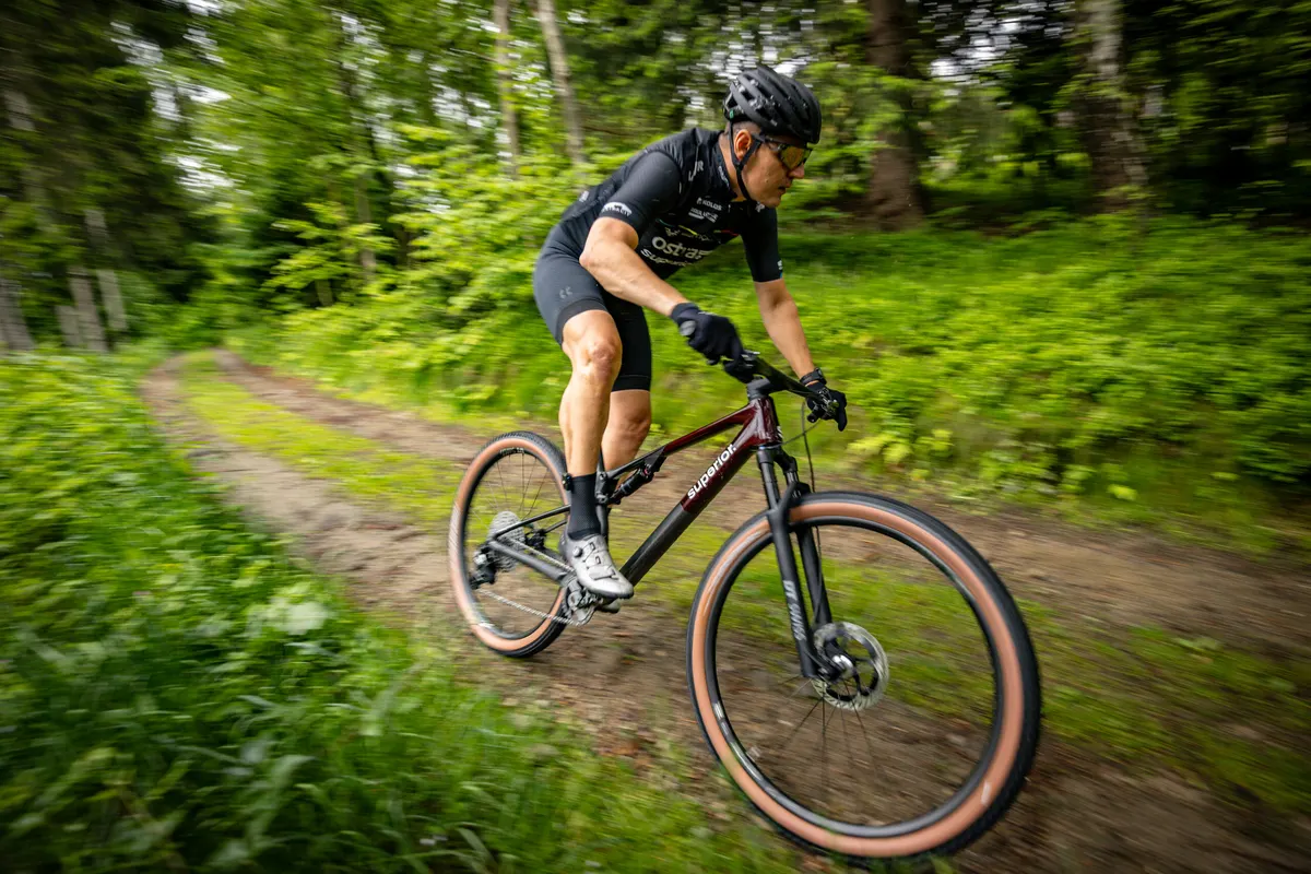 Mountainbiker stuurt door een bocht op een bospad