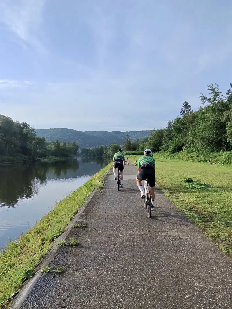Twee fietsers in Vision Sports kleding in een mooie omgeving